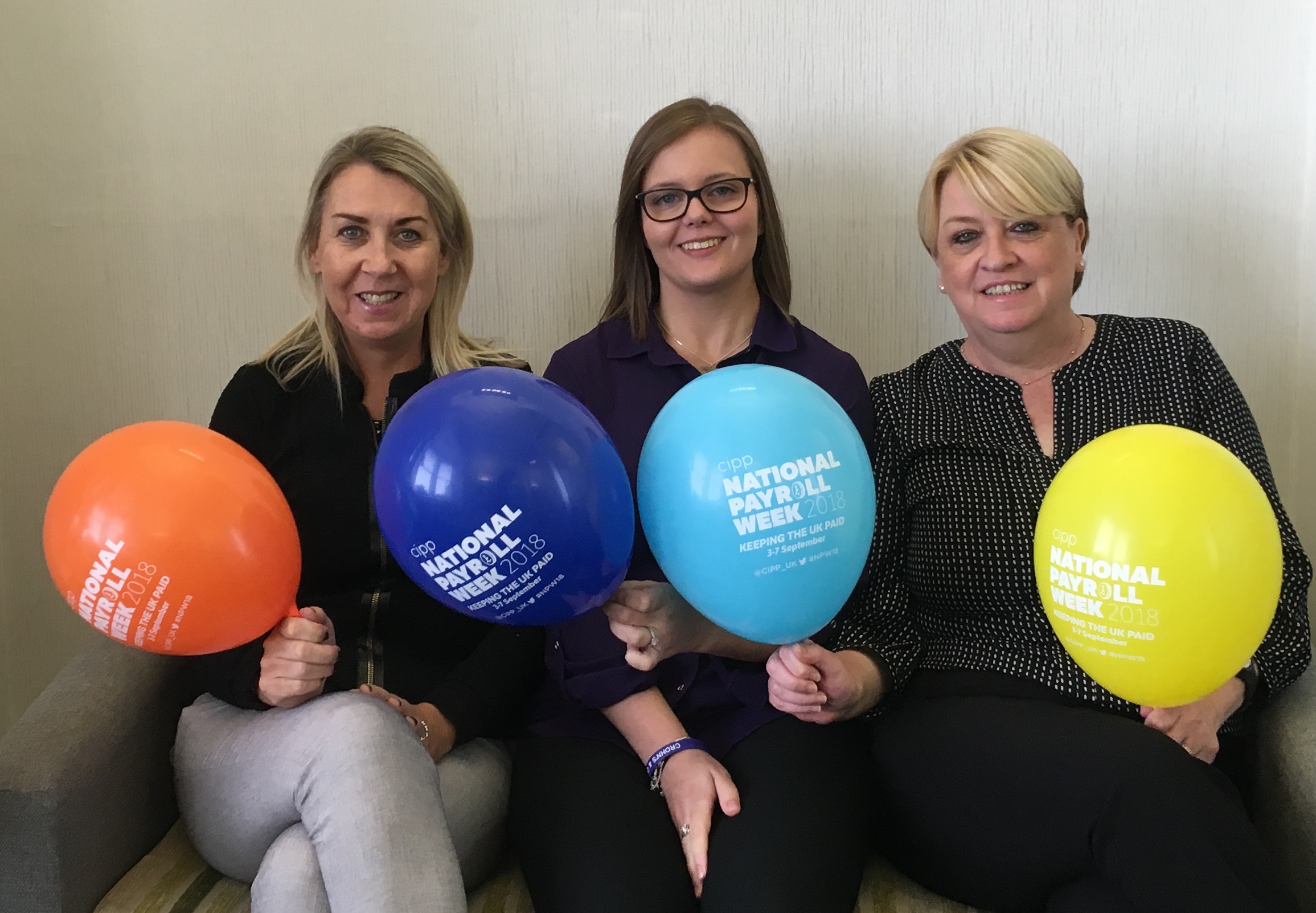 CavanaghKelly Dugannon based Payroll Services team supporting national payroll week - pictured in cavanaghkelly reception area with #NPW18 coloured balloons